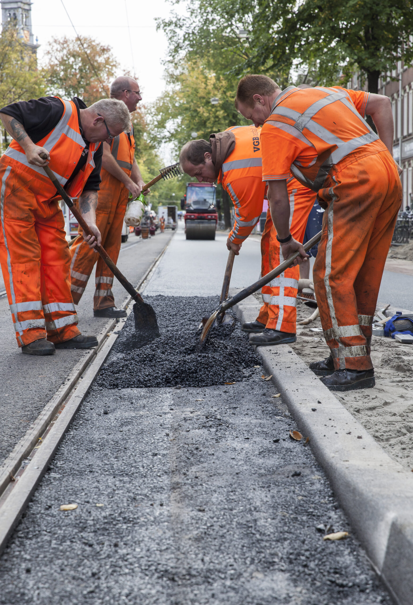 Vier mannen aan het werk met verschillende soorten gereedschap.
